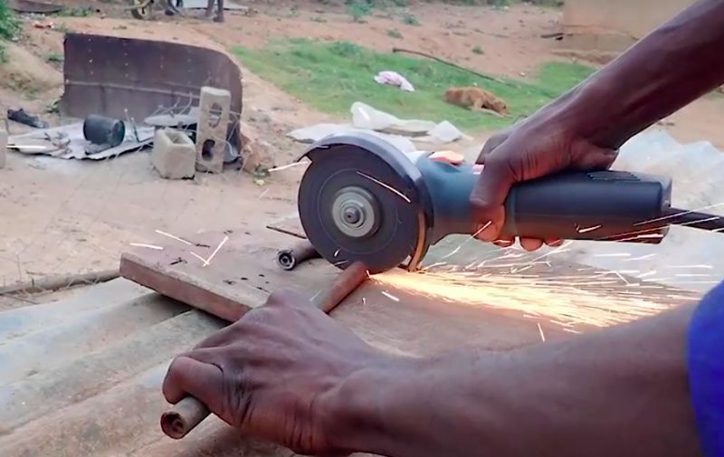 Man uses an angle grinder in Eswatini Africa